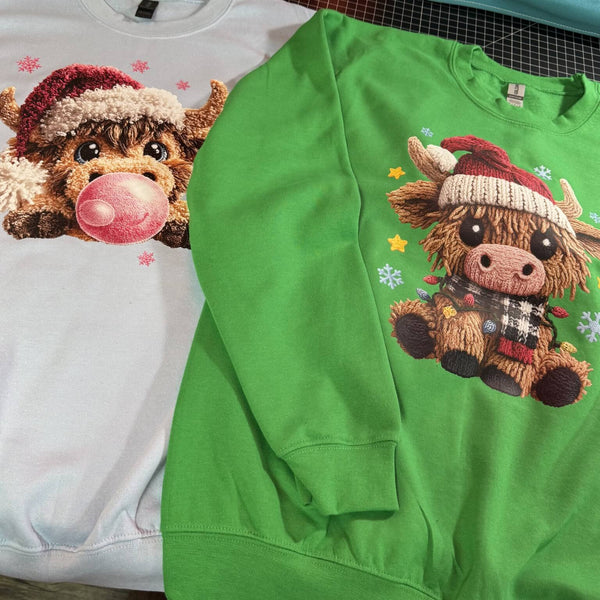 Green sweatshirt with a cartoon cow wearing a Santa hat on a white background