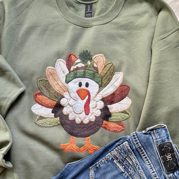 Green sweatshirt with a colorful faux embroidered turkey design on a matching background.