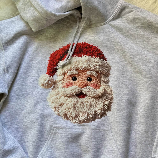 Gray hoodie with a textured yarn Santa Claus face design on a neutral background
