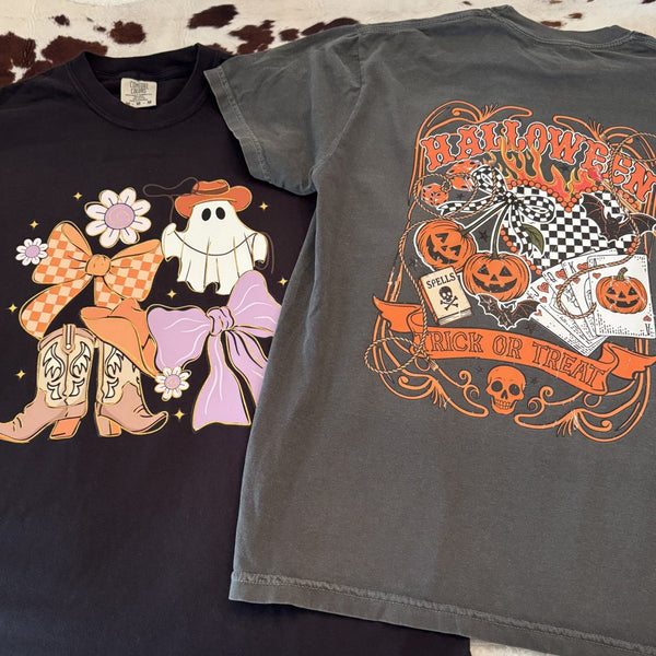 Two Halloween-themed t-shirts on a textured surface.
