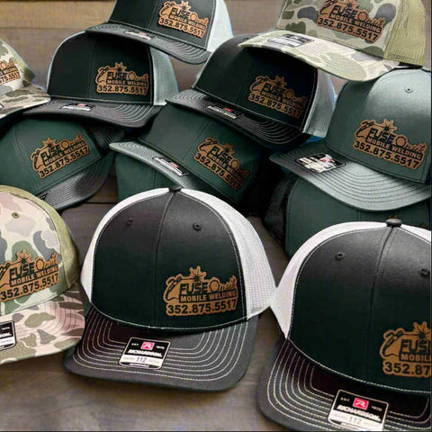 Collection of hats with branding on a pegboard background