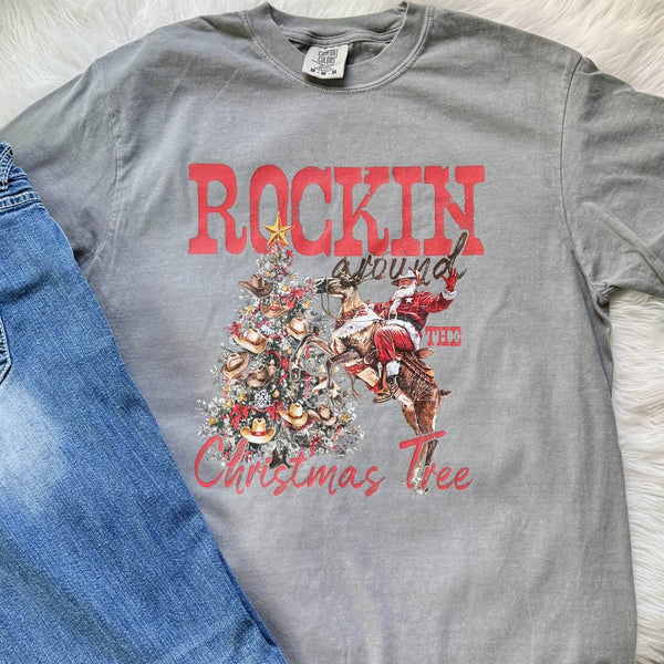 Gray t-shirt with Christmas-themed design featuring Santa Claus and a tree, paired with blue jeans.