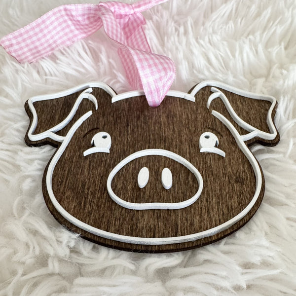 Close-up of 3D layered wooden pig Christmas ornament with raised white face details