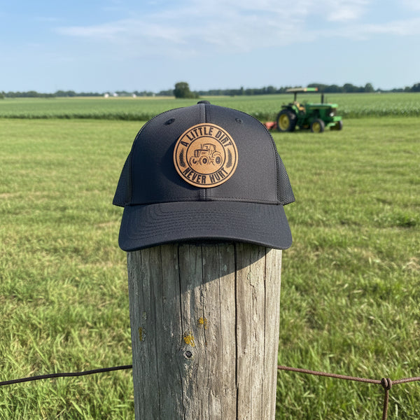 Youth tractor trucker hat with engraved faux leather patch – “A Little Dirt Never Hurt” design in a field