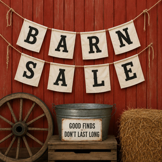 Rustic Barn Sale display with red barn wall, wagon wheel, hay bale, and vintage sign promoting ready-to-ship graphic tees and trucker hats from The Stenciled Barn.