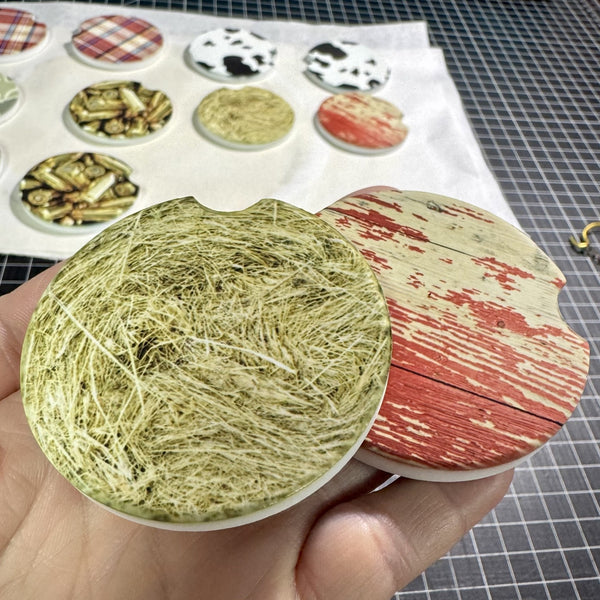 Rustic distressed red barn wood car coaster with weathered farmhouse design and a rustic hay bale car coaster featuring realistic farm hay design for country vehicle décor.