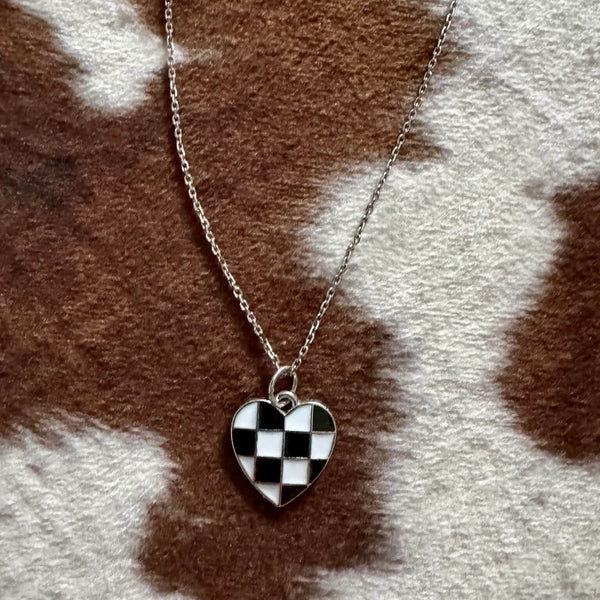Necklace with a checkered heart pendant on a fur background