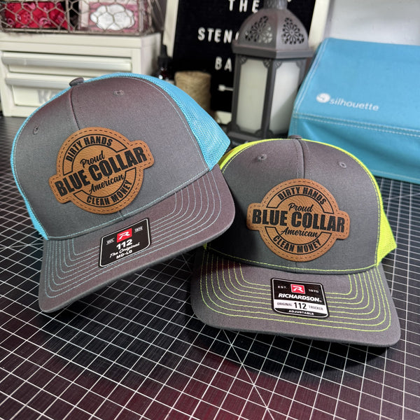 Two gray Richardson 112 blue collar trucker hats with brown leather patches, featuring neon blue and safety green mesh backs.
