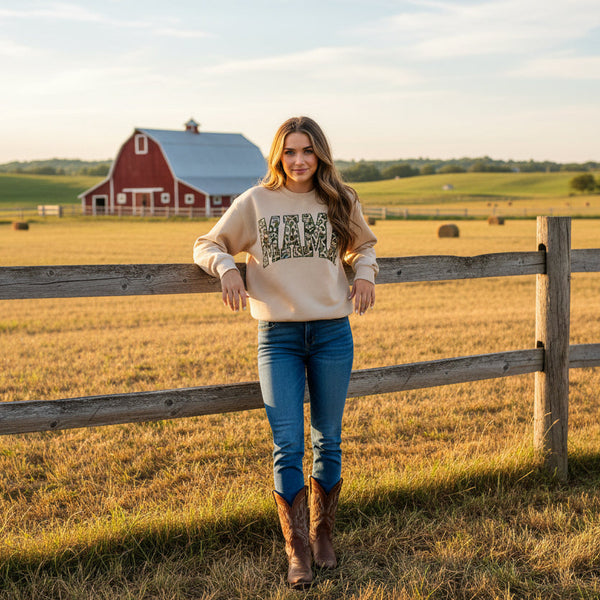 Woman standing by a wooden fence in a field with a red barn in the background