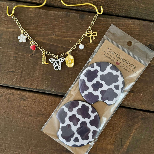 Black cow print car charm necklace with matching black cow print car coasters.