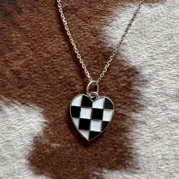 Necklace with a checkered heart pendant on a cowhide background