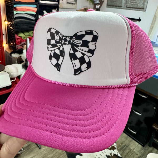 Pink foam trucker hat featuring a black and white checkered bow graphic for race day and motorsports fans.
