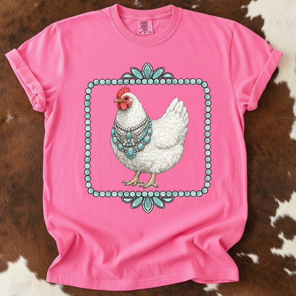 Pink t-shirt with a chicken wearing turquoise jewelry design on a cowhide background