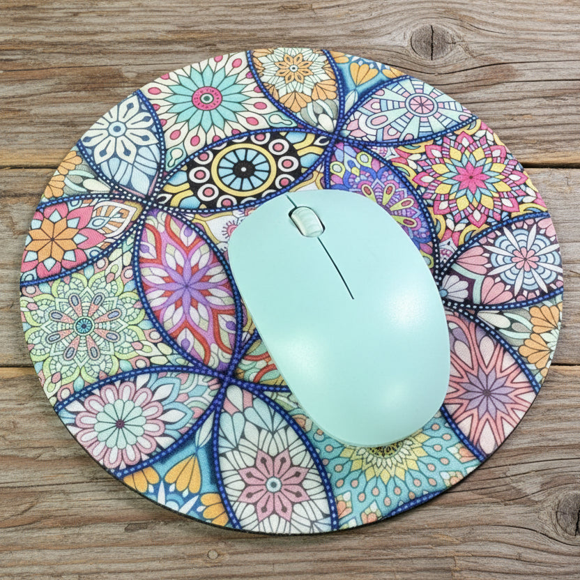 Colorful mandala-patterned mouse pad with a light blue mouse on a rustic wood background