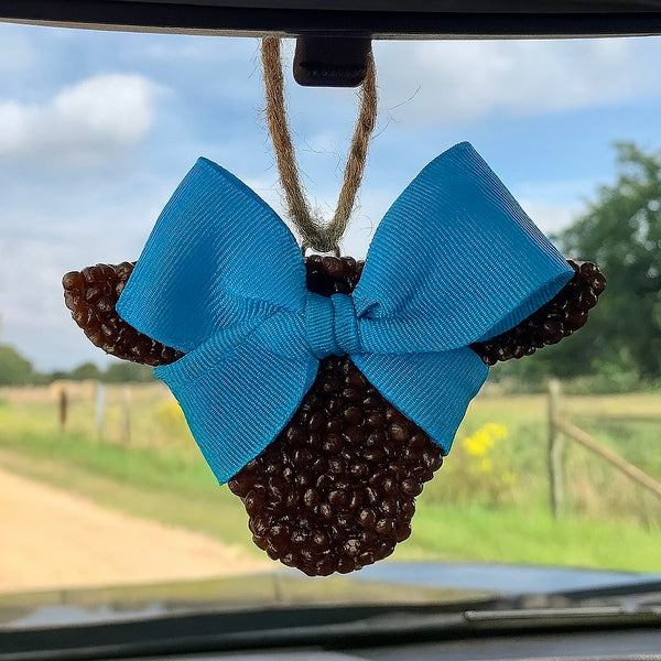 Car air freshener with a blue turquoise bow hanging from a car's rearview mirror.
