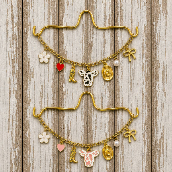 Cow Print Rearview Mirror Charm Necklaces in Black or Pink with Gold Boot, Cowboy Hat, Bow, Pearl, Heart & Flower Charms on Rustic Wood Background