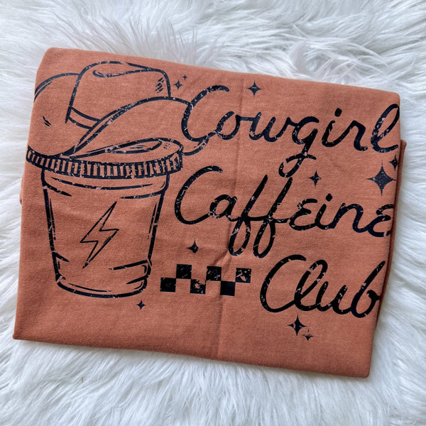 Cowgirl Caffeine Club graphic tee featuring cowboy hat coffee cup design on peach graphic shirt