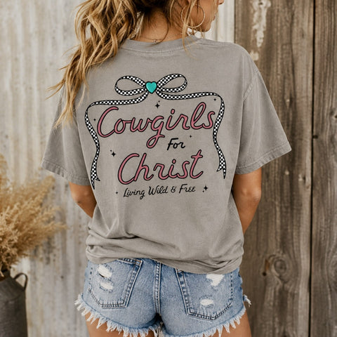 Woman wearing gray Cowgirls for Christ Comfort Colors graphic tee with checkered bow and Christian cowgirl back design