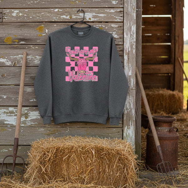 Cows Are My Valentine cow graphic sweatshirt in graphite heather hanging in a barnyard