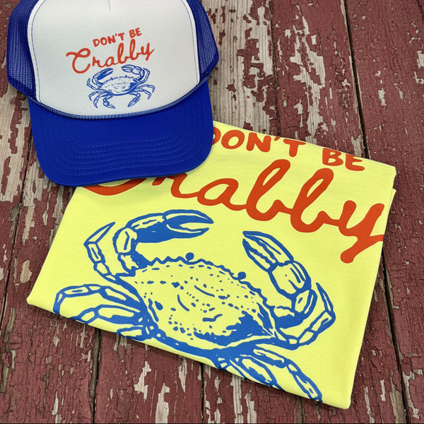 Neon yellow Comfort Colors Don’t Be Crabby graphic tee with matching blue and white trucker hat on rustic barn wood background