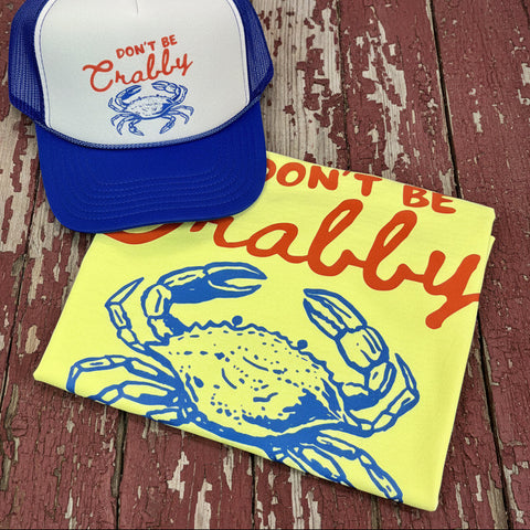 Neon yellow Comfort Colors Don’t Be Crabby graphic tee with matching blue and white trucker hat on rustic barn wood background