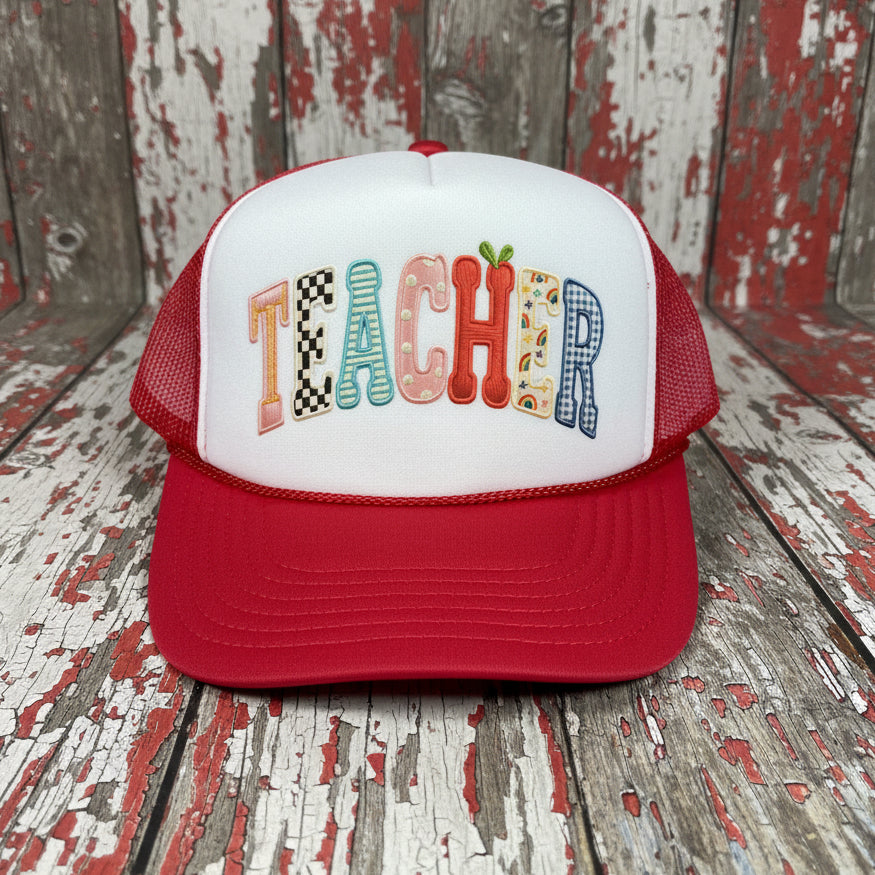 Red and white foam mesh trucker hat with colorful faux applique “TEACHER” lettering on the front panel — cute teacher gift and back to school accessory