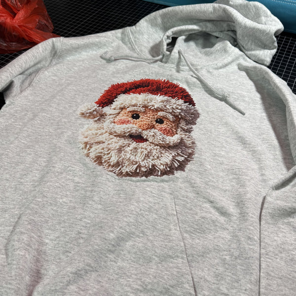 Ash gray Christmas hoodie featuring a faux yarn Santa Claus face graphic with textured knitted-look holiday design.