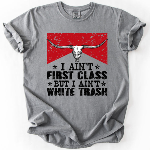 Gray Comfort Colors I Ain't First Class But I Ain't White Trash graphic tee with distressed red longhorn skull design.