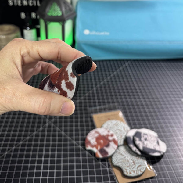 Flexible neoprene car coaster being bent to show softness and absorbent backing