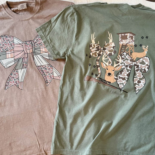 Two t-shirts, one brown and one green, with decorative designs of bows and deer.