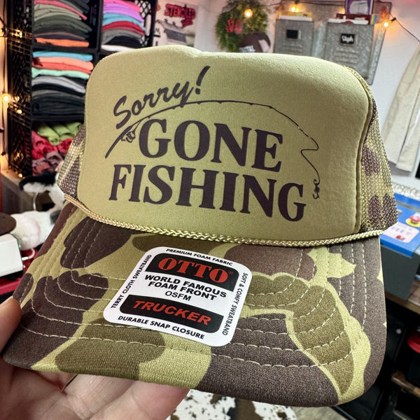 Gone Fishing camouflage trucker hat with fishing graphic on olive foam front and camo bill.