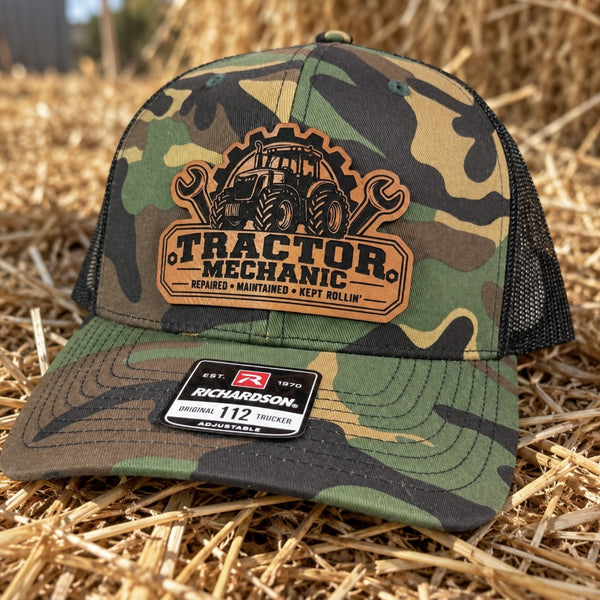 Green camo Tractor Mechanic leather patch trucker hat sitting on hay