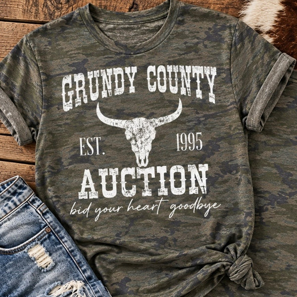 Grundy County Auction camo graphic tee with vintage white longhorn skull design styled with distressed denim on rustic wood