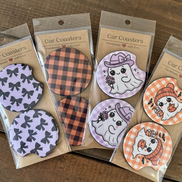 Packaged car coasters with cute Halloween designs on a wooden surface
