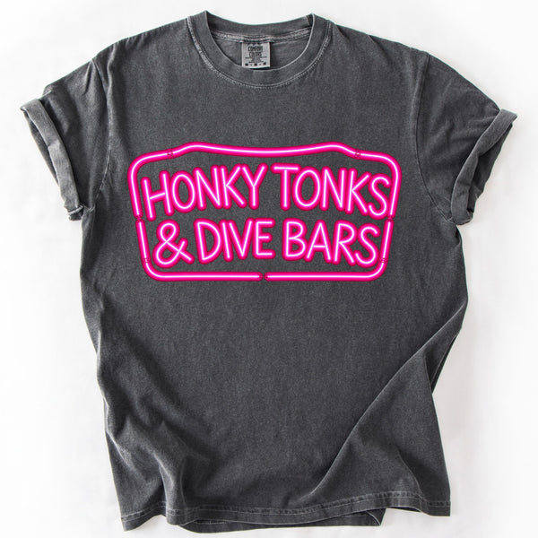 Pepper Comfort Colors country graphic tee featuring bright pink Honky Tonks & Dive Bars neon sign design on a white background.
