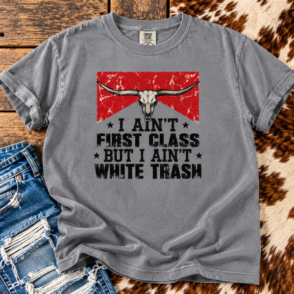 Vintage country graphic tee in washed gray featuring a longhorn skull and distressed lettering, styled with ripped denim and cowhide.