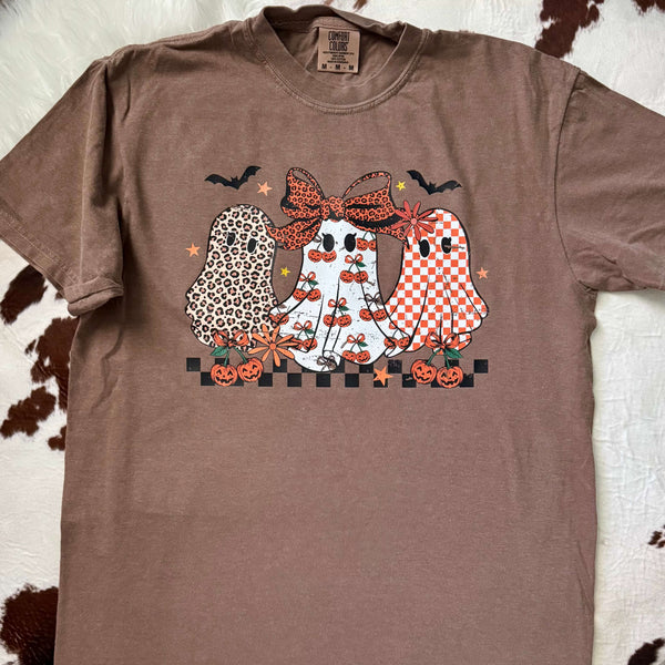 Brown t-shirt with Halloween-themed design of ghosts on a textured surface