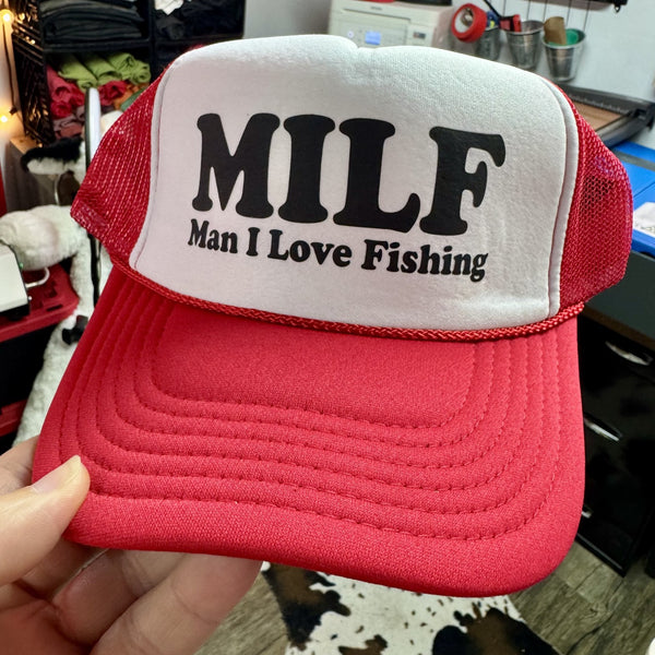 Red and white foam trucker hat with MILF Man I Love Fishing graphic for fishing enthusiasts and outdoor lovers.