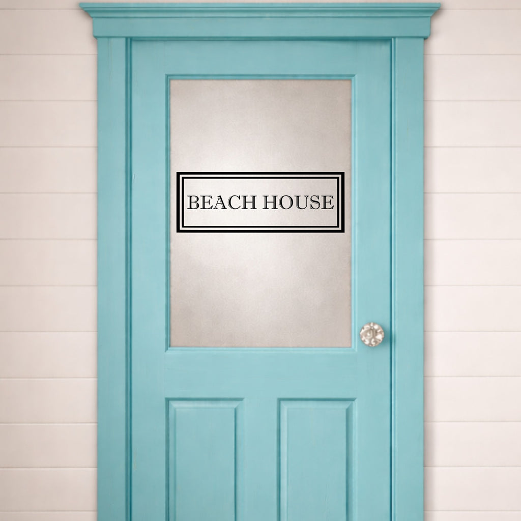 Light blue door with 'Beach House' door sign and a white wall