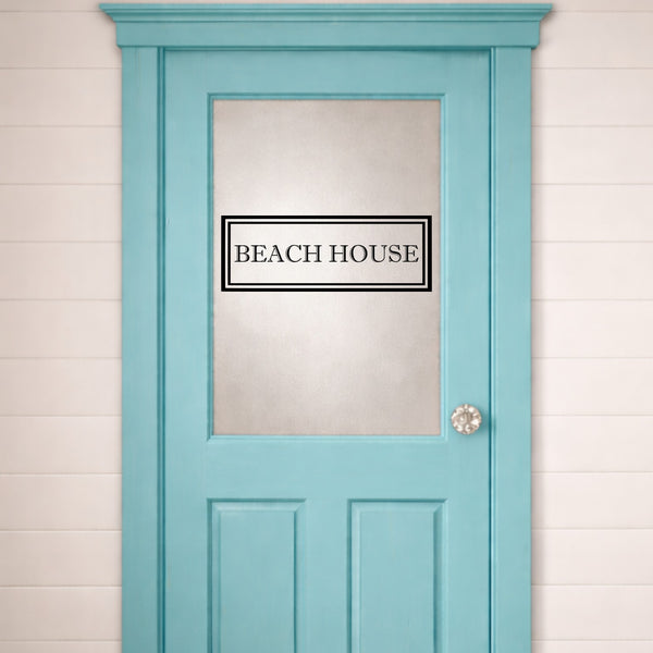 Light blue door with 'Beach House' door sign and a white wall