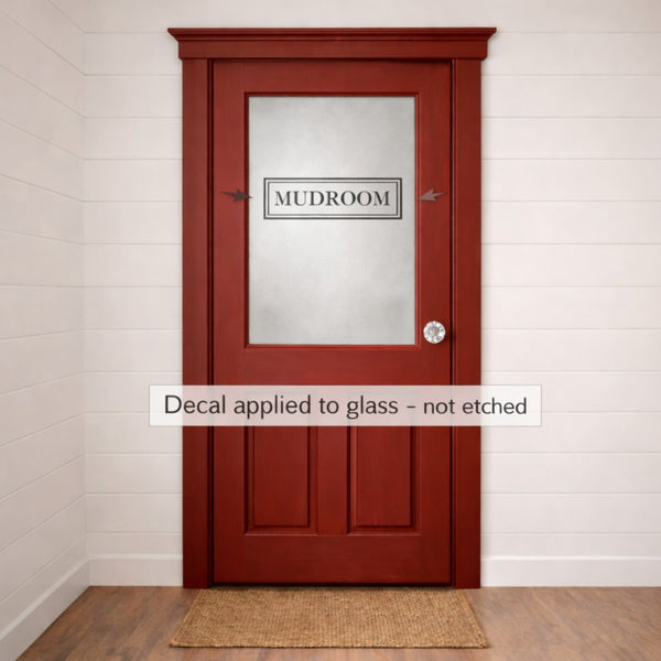 Red door with 'MUDROOM' decal on glass panel in a hallway.