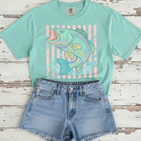 Pastel bass fish graphic printed on Island Reef Comfort Colors tee with denim shorts and cowboy boots on rustic wood background