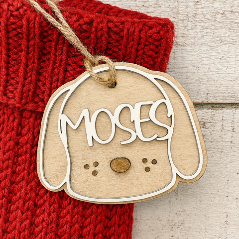 Wooden dog-shaped tag with personalized name on a red fabric Christmas stocking background