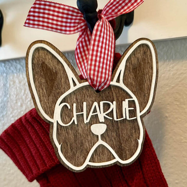 Wooden French Bulldog face-shaped ornament engraved name with a red checkered ribbon hanging on a Christmas Stocking