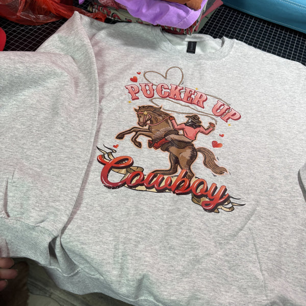 Pucker Up Cowboy graphic sweatshirt on ash gray Gildan crewneck featuring rodeo cowgirl and horse western design, size large
