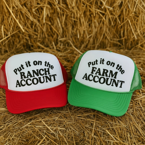 Red and green “Put it on the Ranch Account” and “Put it on the Farm Account” funny trucker hats on a hay bale – The Stenciled Barn