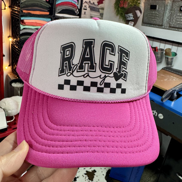 Pink foam trucker hat featuring Race Day graphic with checkered racing design for race fans and track days.