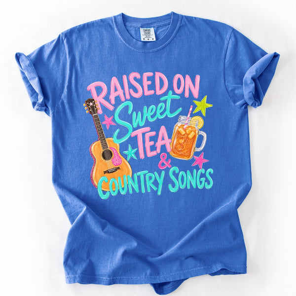 Comfort Colors graphic tee with Raised On Sweet Tea & Country Songs retro southern design featuring guitar and sweet tea graphic laid flat on white background