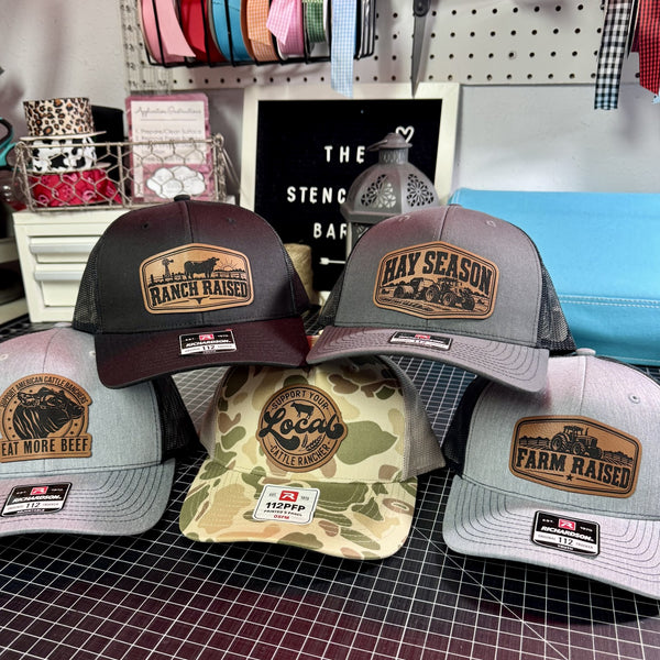 Farm and ranch trucker hats for adults and youth featuring cattle, tractor, Hay Season, Ranch Raised and Farm Raised leather patches.