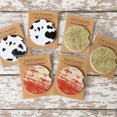 Rustic farmhouse car coasters featuring faux cow print, weathered barn wood and hay bale designs available in ceramic or neoprene.